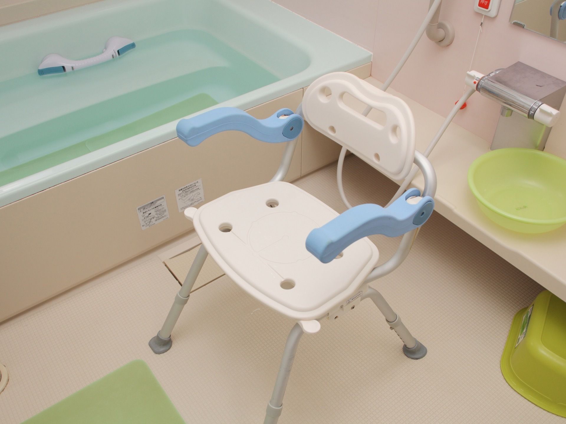 毎日丁寧に清掃された浴室で、気持ちよく入浴できる。ホワイトとブルーの介護専用シャワーチェアが完備されている。