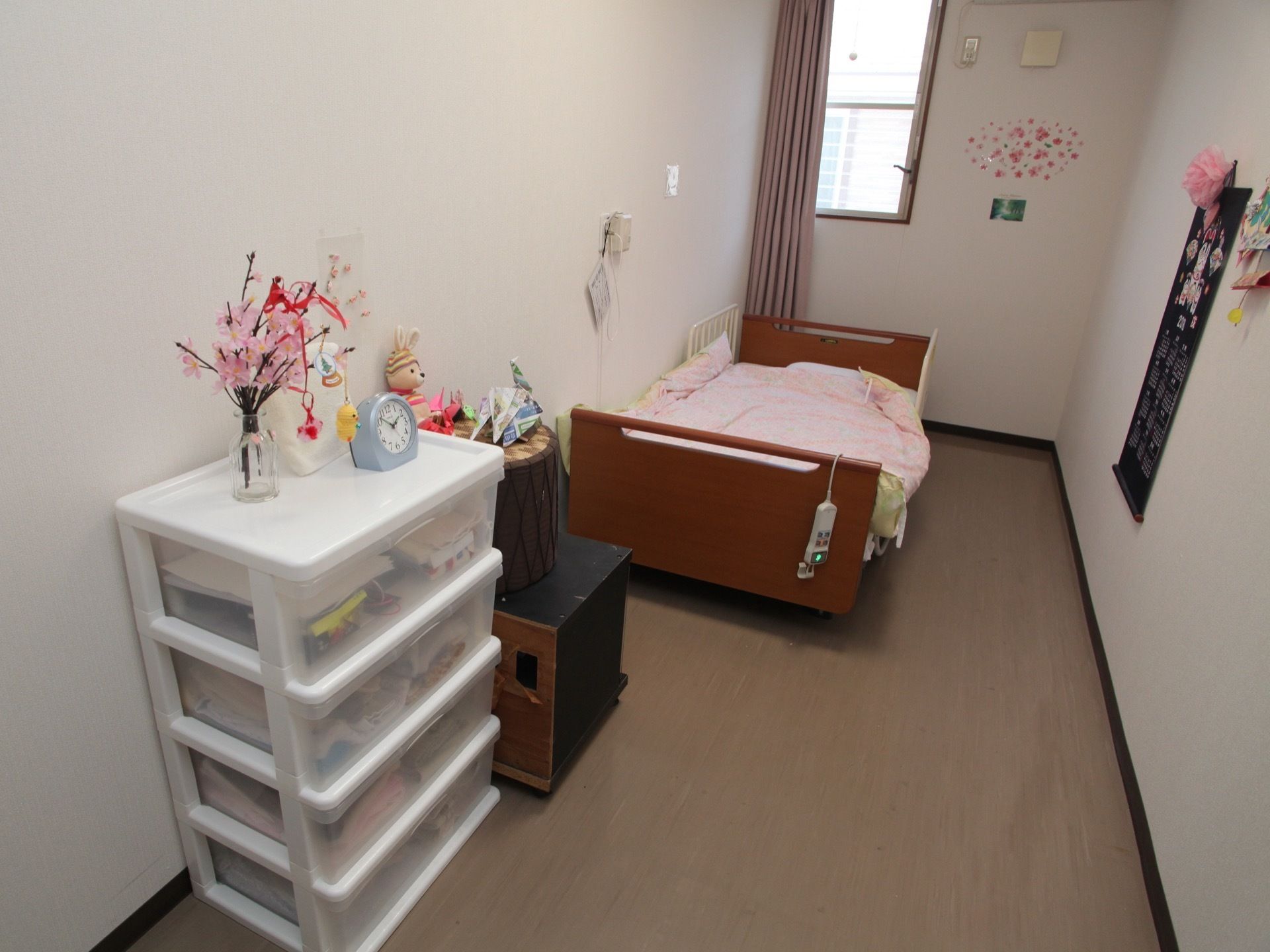 縦長で奥行き感のある居室である。縦窓が設置され、光を取り込んでいる。電動式の介護用ベッド、収納家具も完備。
