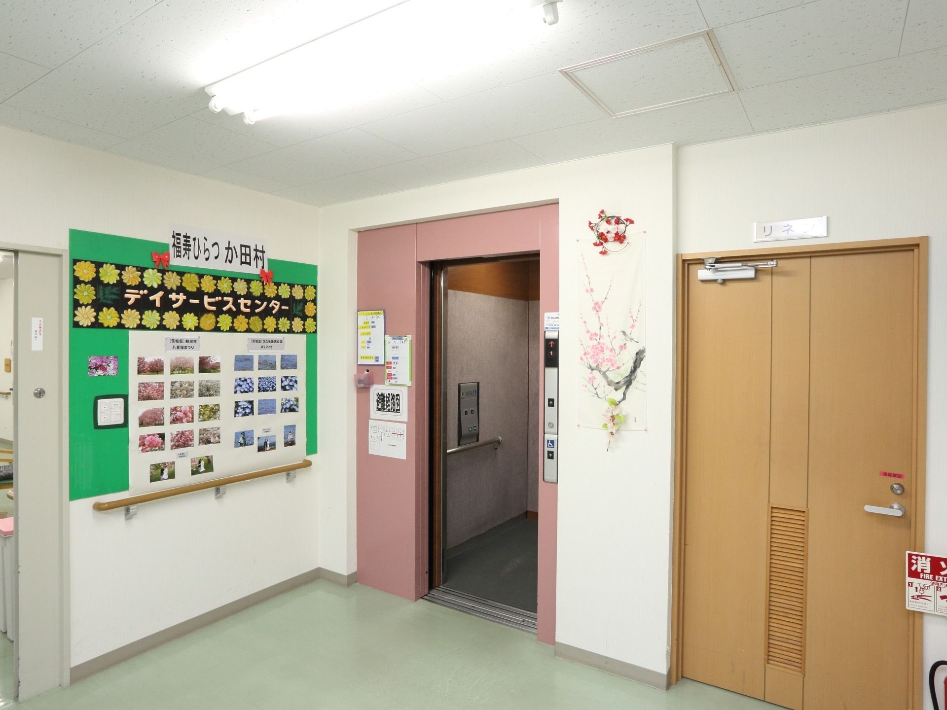 施設内に完備されたエレベーターである。壁には掲示板が設置されレイアウトされている。フロアーには消火器が置かれている