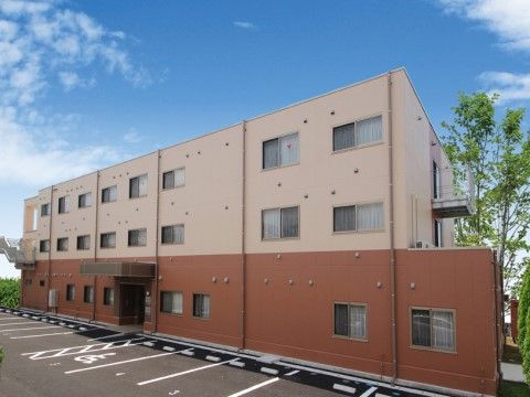 住宅型有料老人ホーム福寿よこはま栄の外観。ピンクと茶色がおしゃれな雰囲気を醸している施設外壁。大きな駐車スペースをご用意しております。