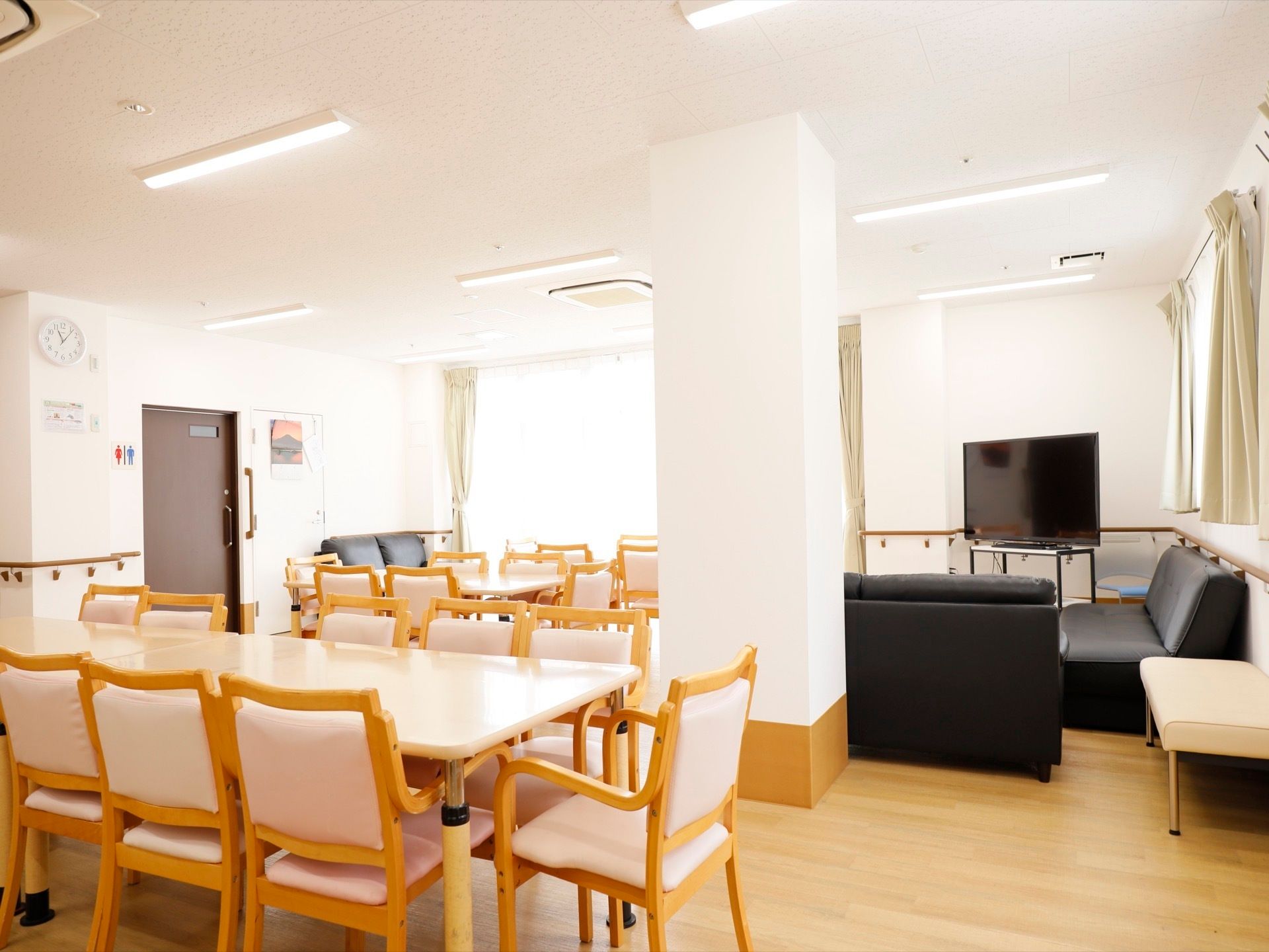 清潔感のある空間で、多くの入居者様が座れるように椅子が用意されている。大きなテレビも用意されており、くつろげる。