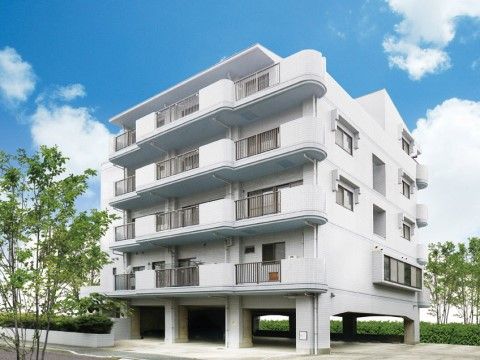 １階が駐車場となっている薄いグレーの外観を持つ５階建て施設
