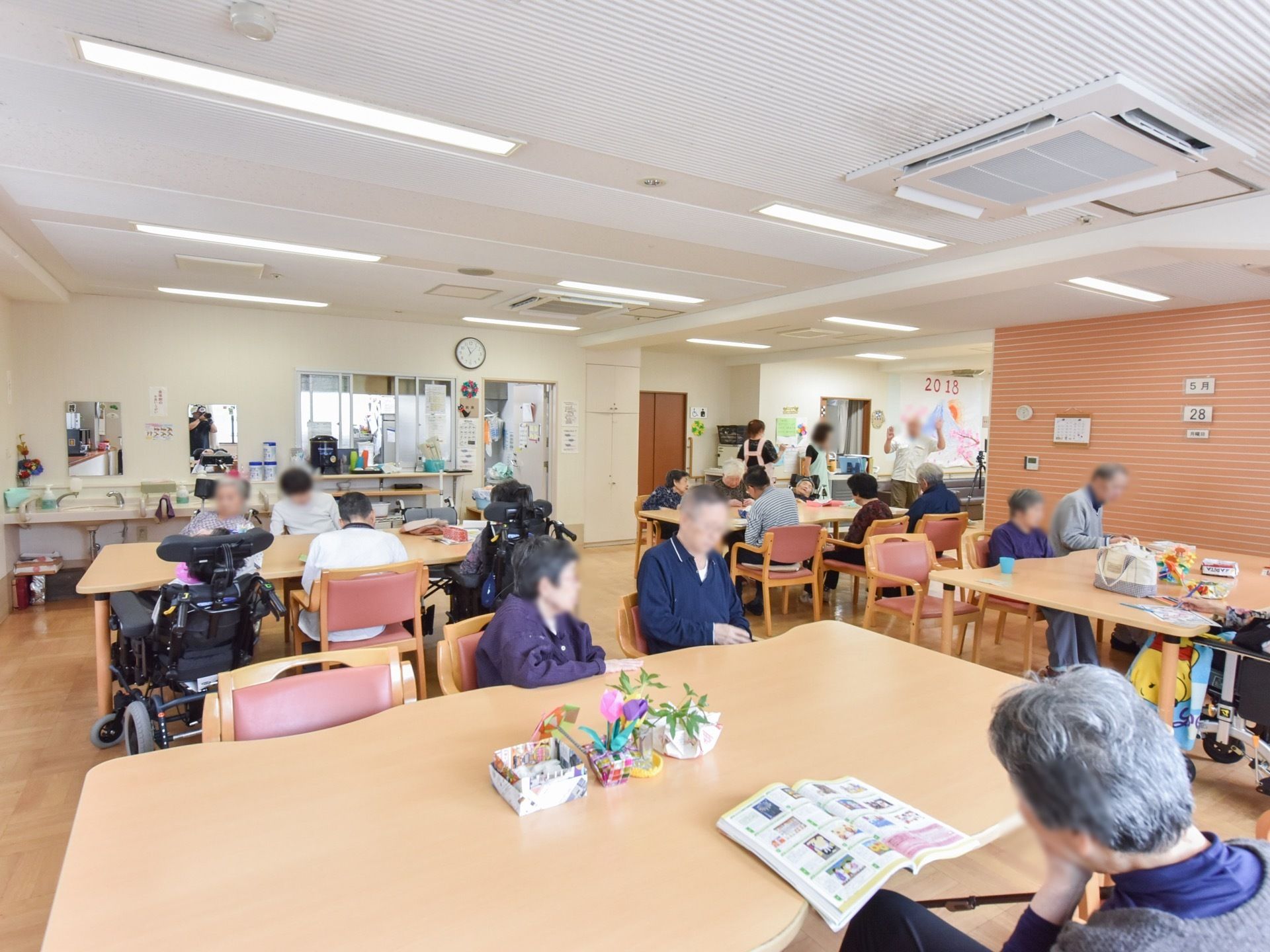 入居者様が集まる食堂では、さまざまな作業をしたり交流を楽しむことができる。テーブルの上には折り紙で作られたチューリップが飾られている。
