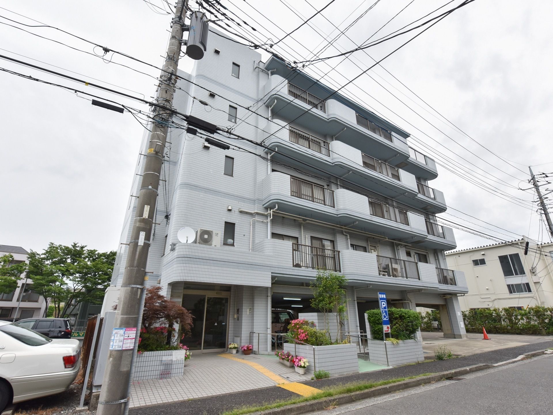 ブルーグレーのタイルの壁が印象的な建物になっており、１階部分は駐車場となっている。スロープがついており、移動が楽に行える。