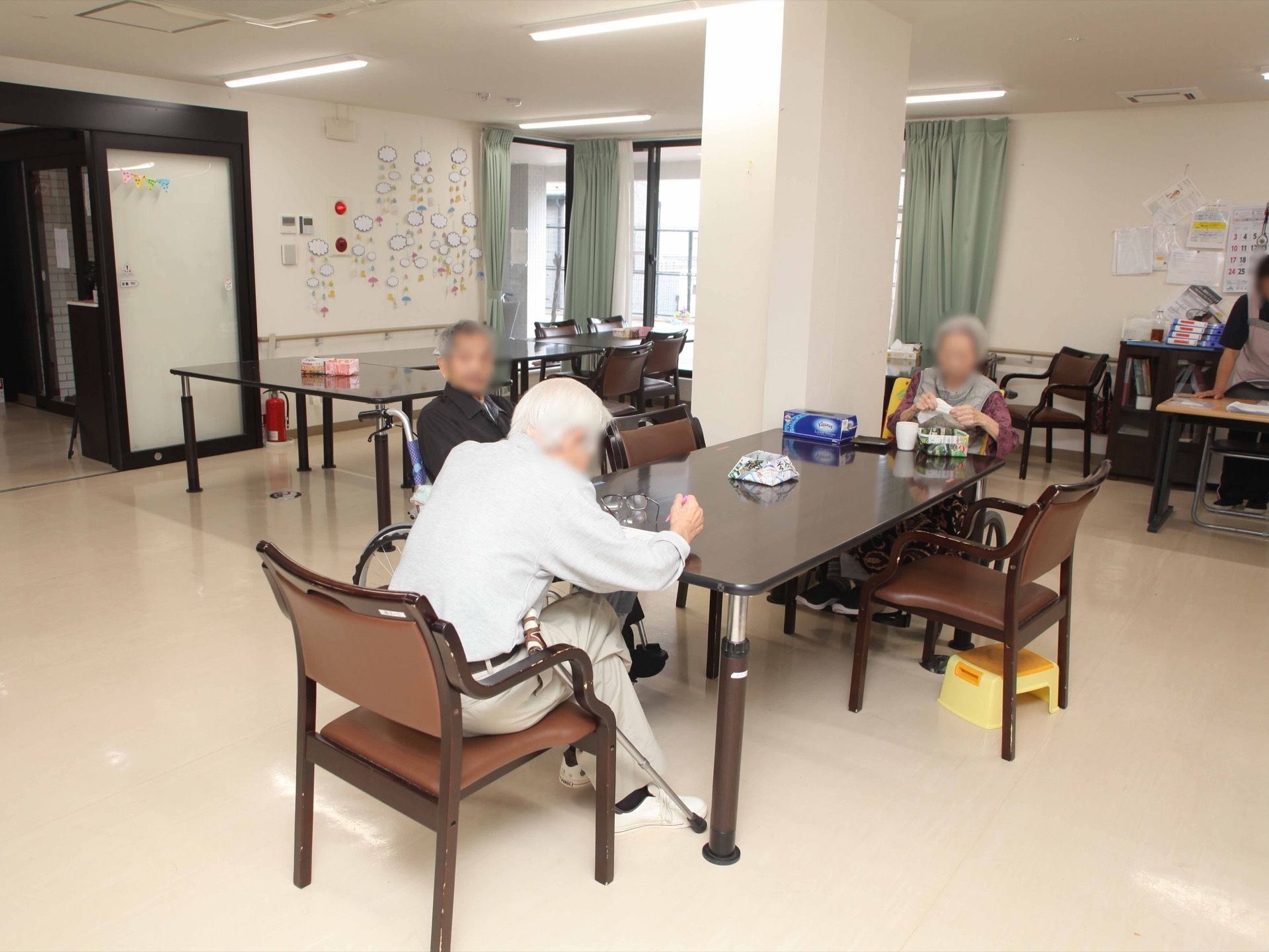 共有スペースにて、入居者様方がコミュニケーションをとっている様子である。自由に利用できる賑やかな空間となっている。