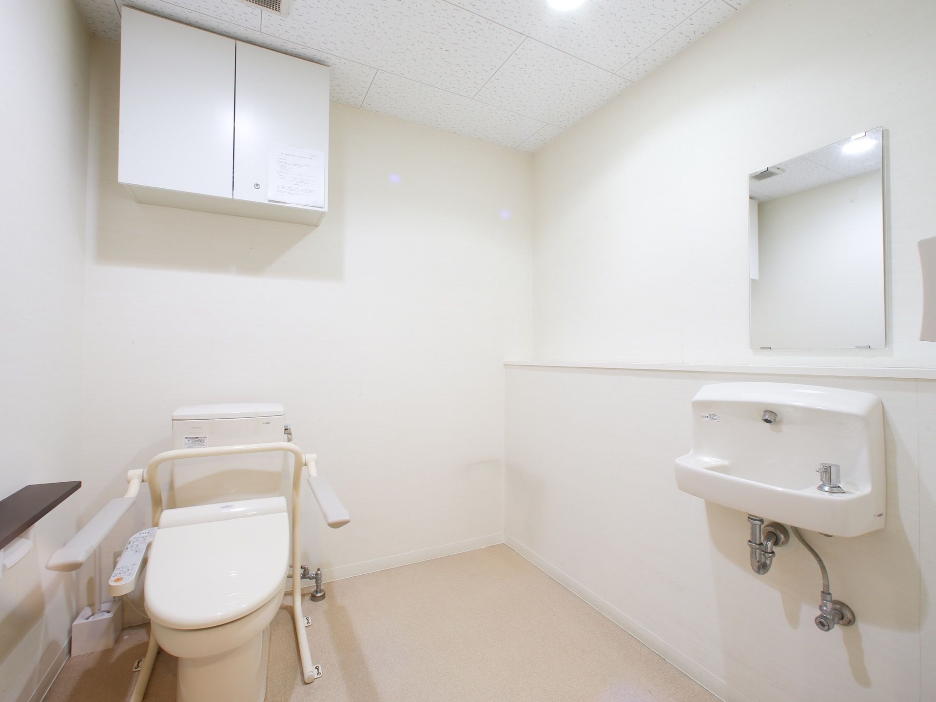要介護の入居者様にも使っていただけるように設計されているトイレである。転倒防止の手すりも完備している。