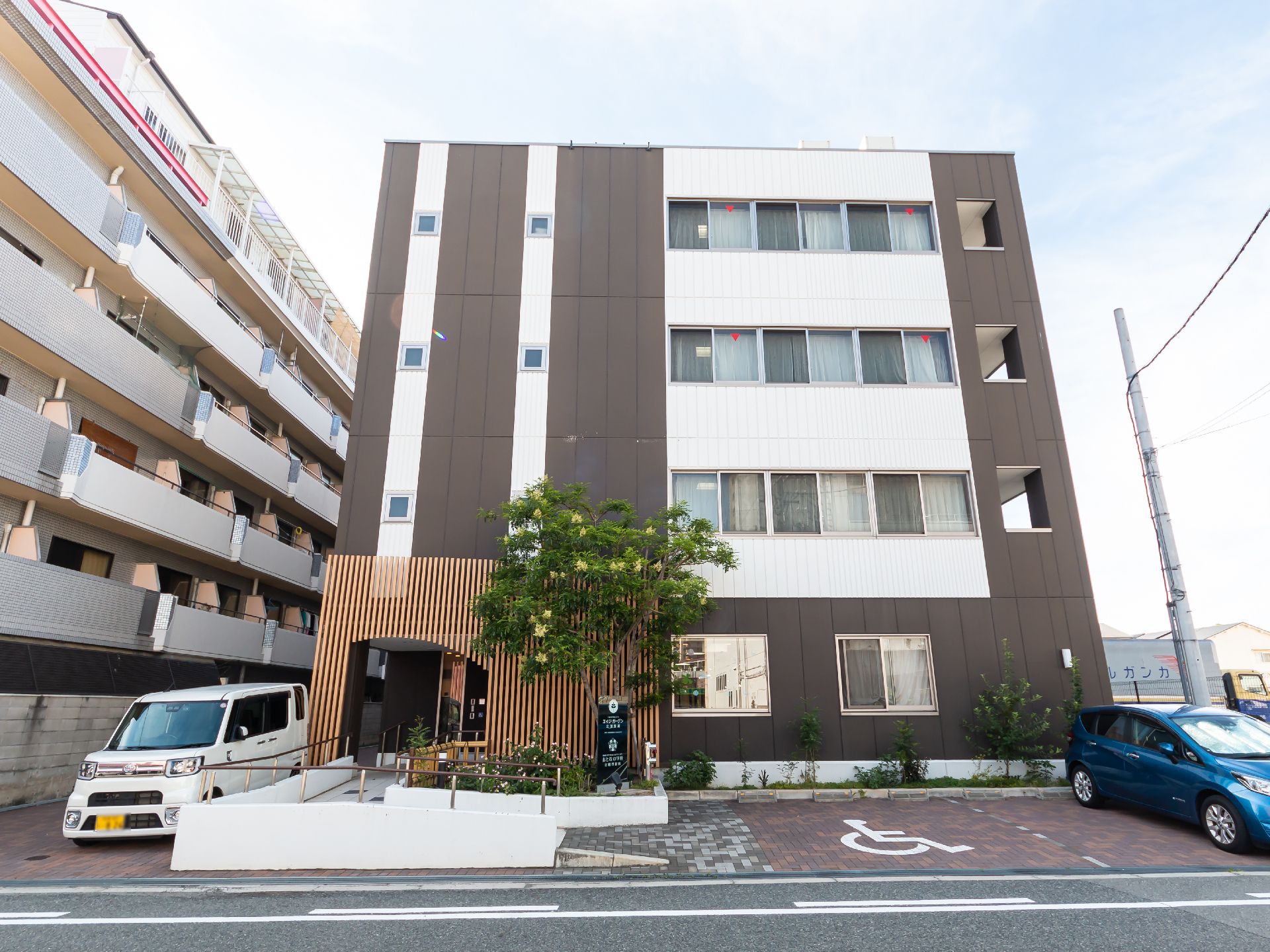 駐車場とスロープが設置してある介護施設の外観