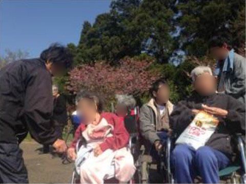 車椅子で外出する高齢者と介助スタッフ