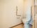 居室にはそれぞれ個室タイプのトイレが存在する。壁にはＬ字の形をした木製の手すり、そしてナースコールがある。