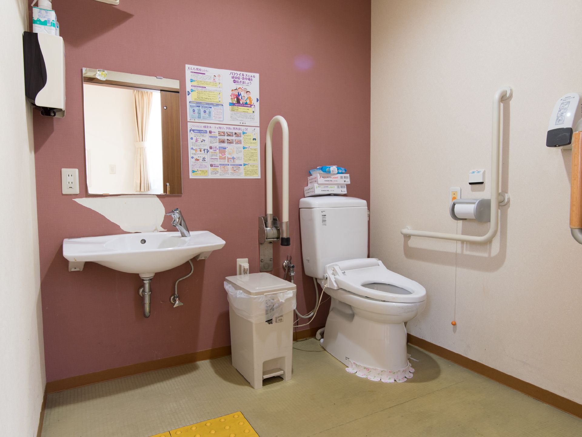 薄紅色で飾られたトイレは車椅子の方でも利用でき、両サイドに立ち上がりをサポートする手すりとコールボタンがあるので安心で使うことができます。
