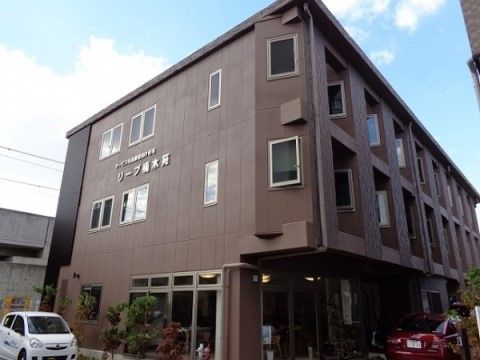 シックな茶系の外観と採光を考慮して設置された各部屋の窓が特徴の３階建て施設