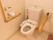 トイレはふたなしの便座である。トイレットペーパーホルダーの近くに、呼び出しボタンや手すりが取り付けられている。
