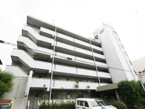 周りに木々が植えられたマンションのような建物