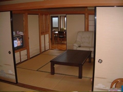 テレビやソファが置かれている、中央に大きな座卓がある和室