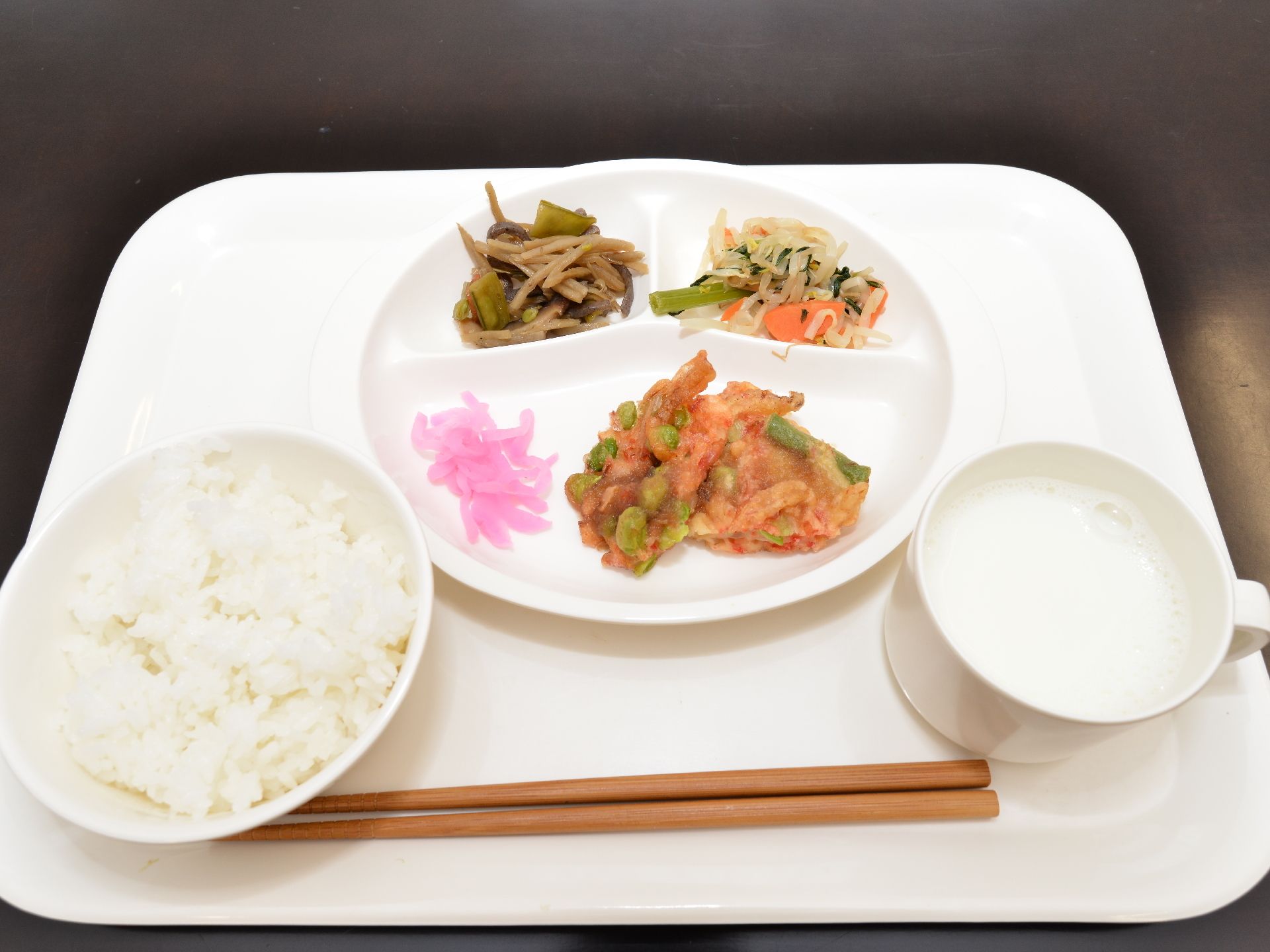 メニューの彩りが映える白の食器でまとめた食事。おかずは仕切りのついたワンプレートディッシュに盛り付けてある。