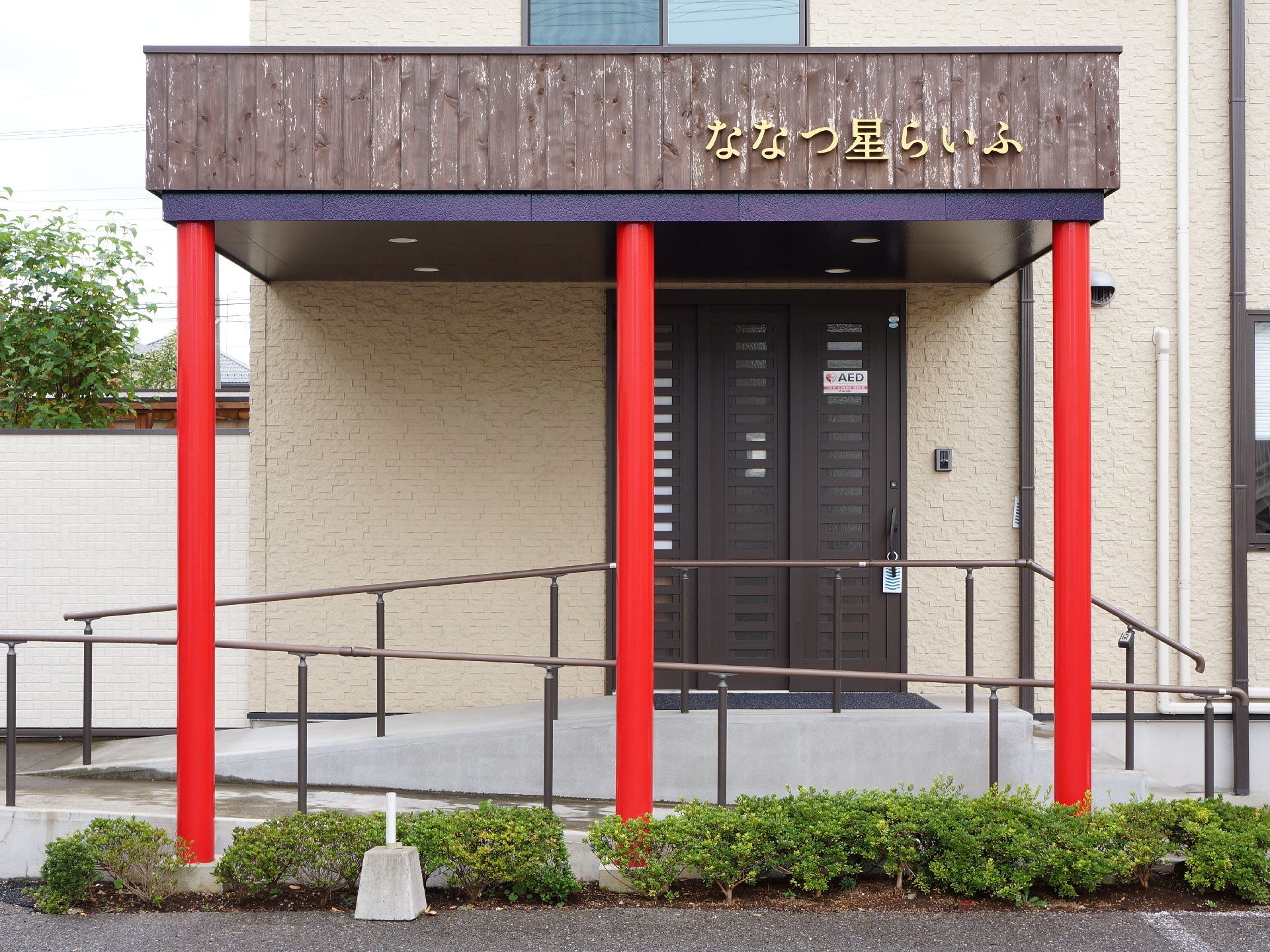 とてもおしゃれな雰囲気である。扉の前はスロープ状になっており、利用しやすい工夫がされている。入口には屋根がついている。