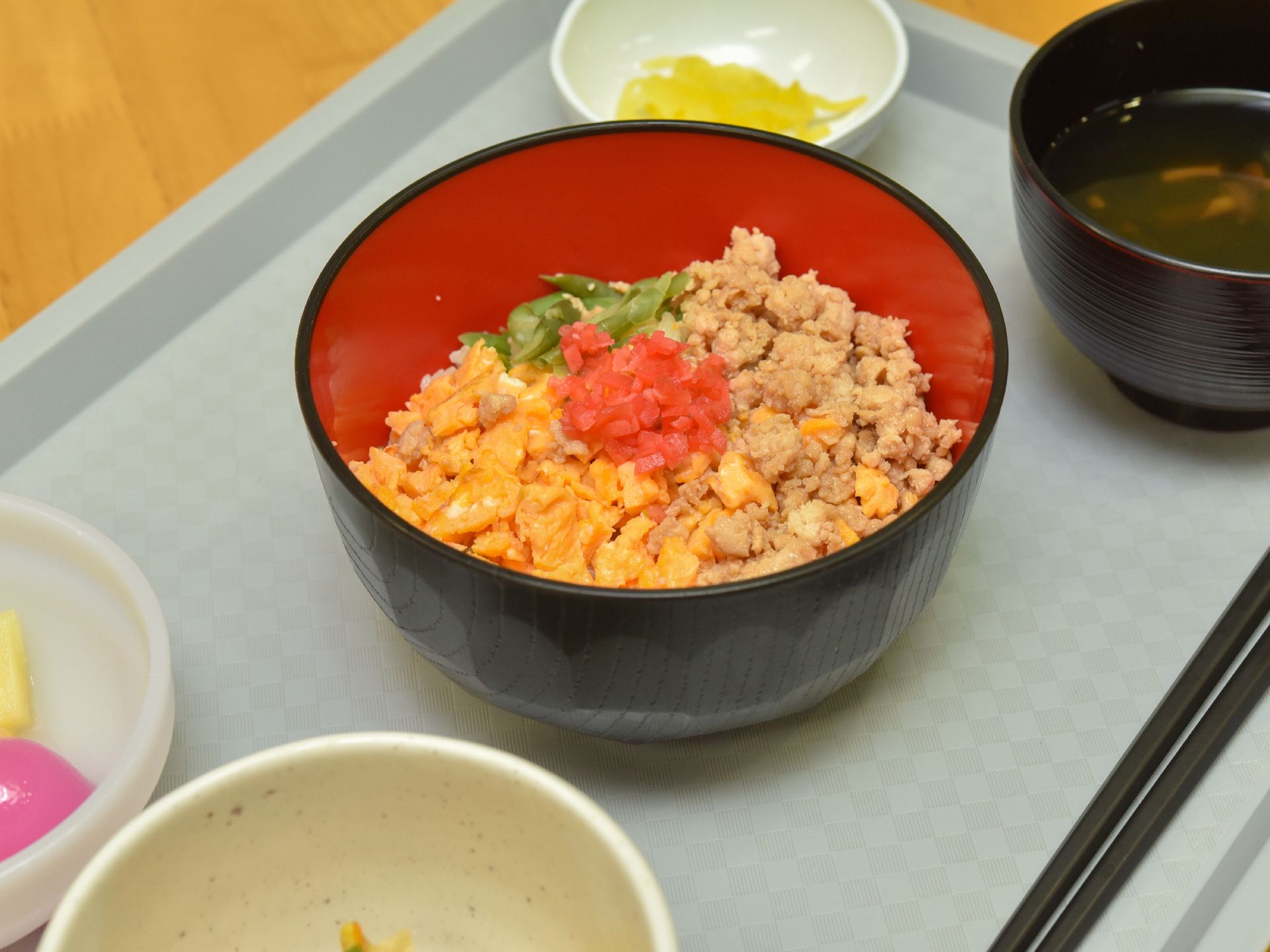 お味噌汁やお漬物、3色そぼろ丼などが並んでいるトレー
