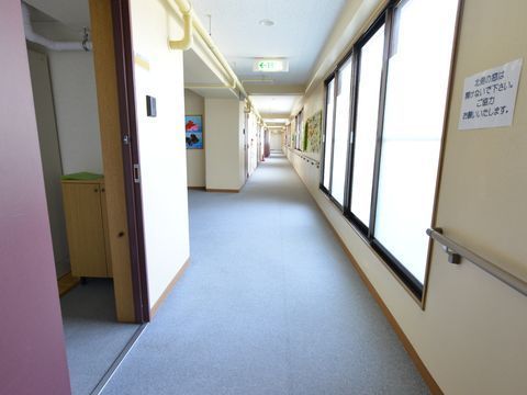 窓からの陽射しが明るく差し込む、手すりが完備されている広々とした廊下