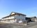 閑静な住宅地に立地している施設の画像。建物はベージュの外壁の２階建てになっており、敷地内には駐車スペースがある。