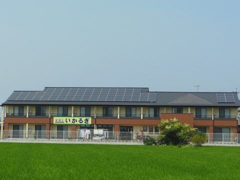 緑豊かな環境の中に建っている、ブラウンのアクセントが印象的な2階建ての建物