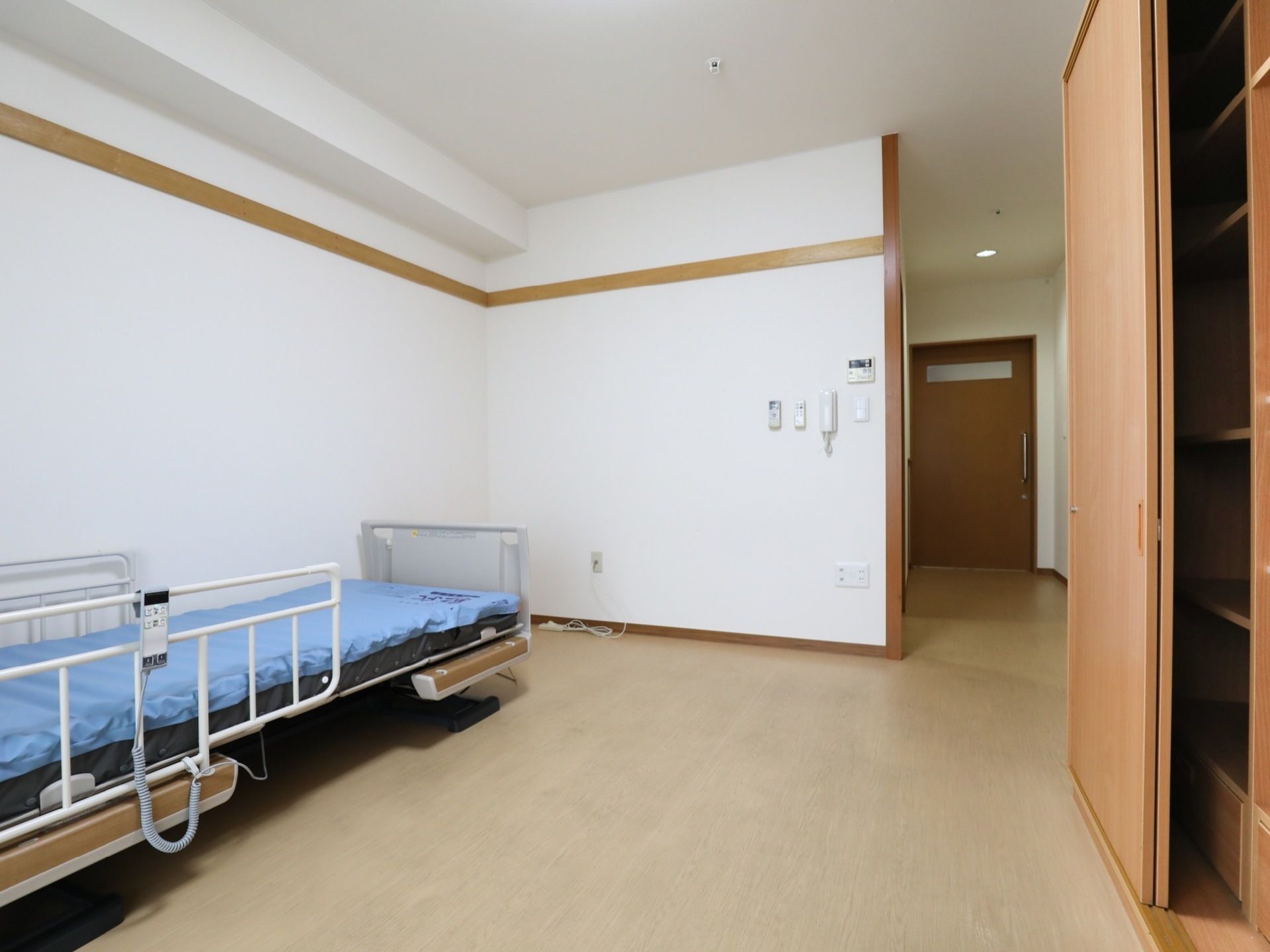 ベッドと収納家具が置かれている、広々とした居住スペース