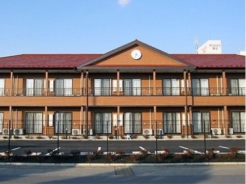 落ち着いた印象の、正面に時計が設置されている2階建ての建物