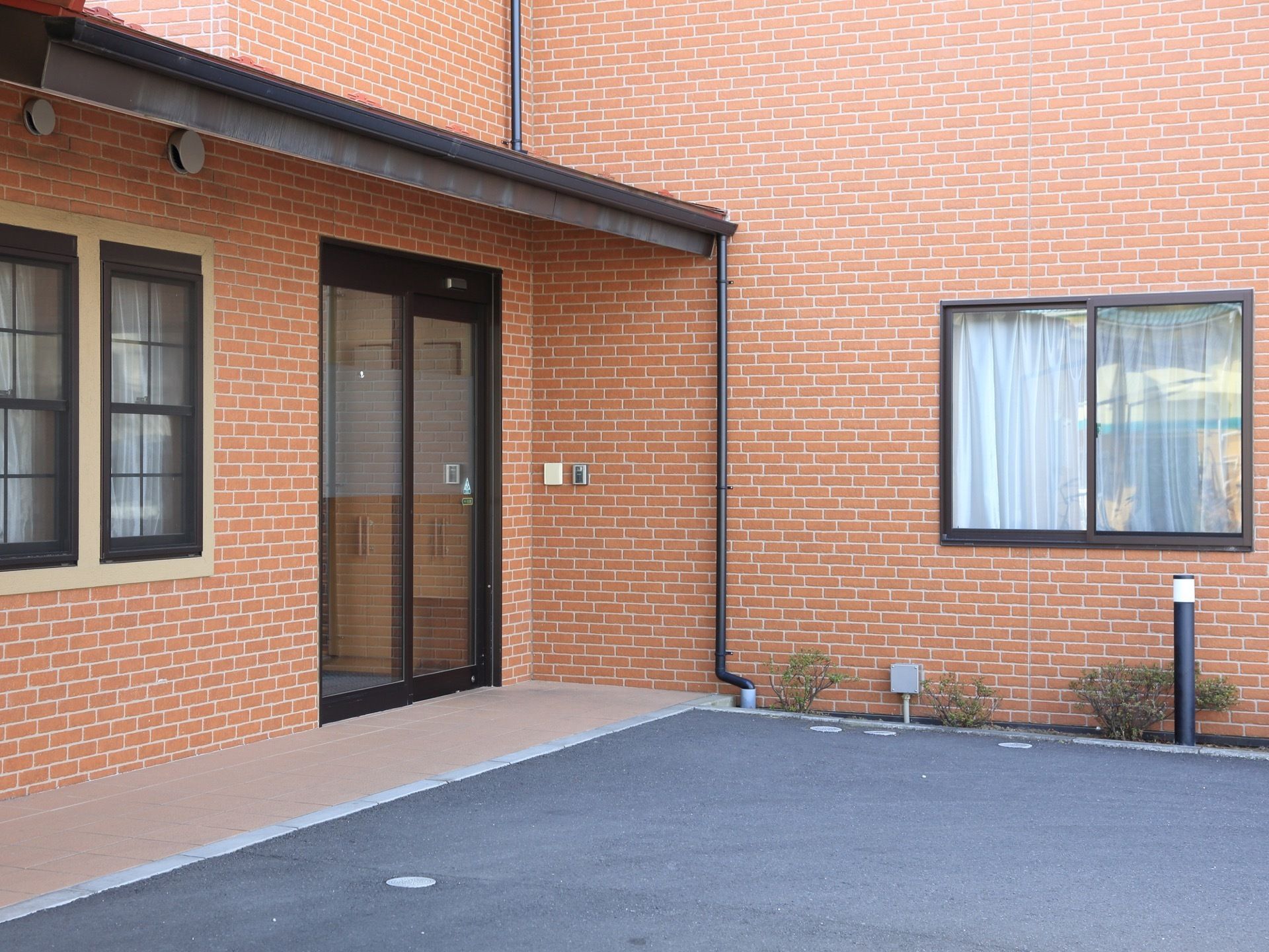 居住棟への入口は自動ドアで、アスファルト敷きのスペースから段差がないので、車椅子をご利用の方でもスムーズに移動できる。