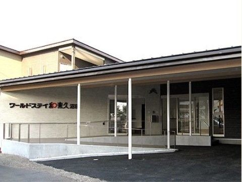 屋根と手すりが完備されたスロープがエントランスまで続いている建物