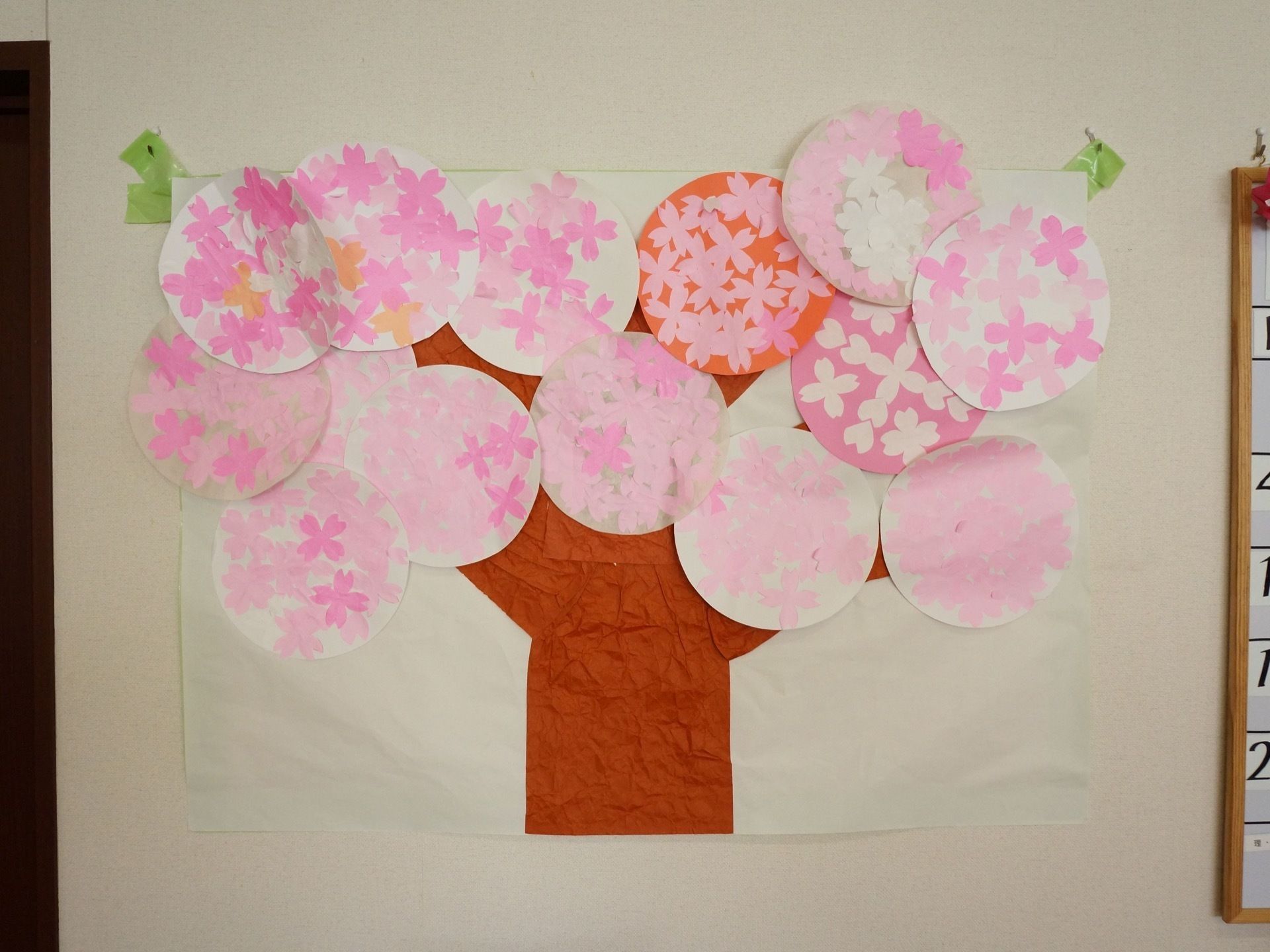壁にスタッフと入居者様で作った桜の絵が飾ってある。施設では毎日色々なレクリエーションが行われている。