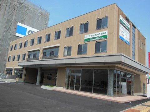 屋根付きのエントランスがある、ブラウンの色調が優しい印象の建物