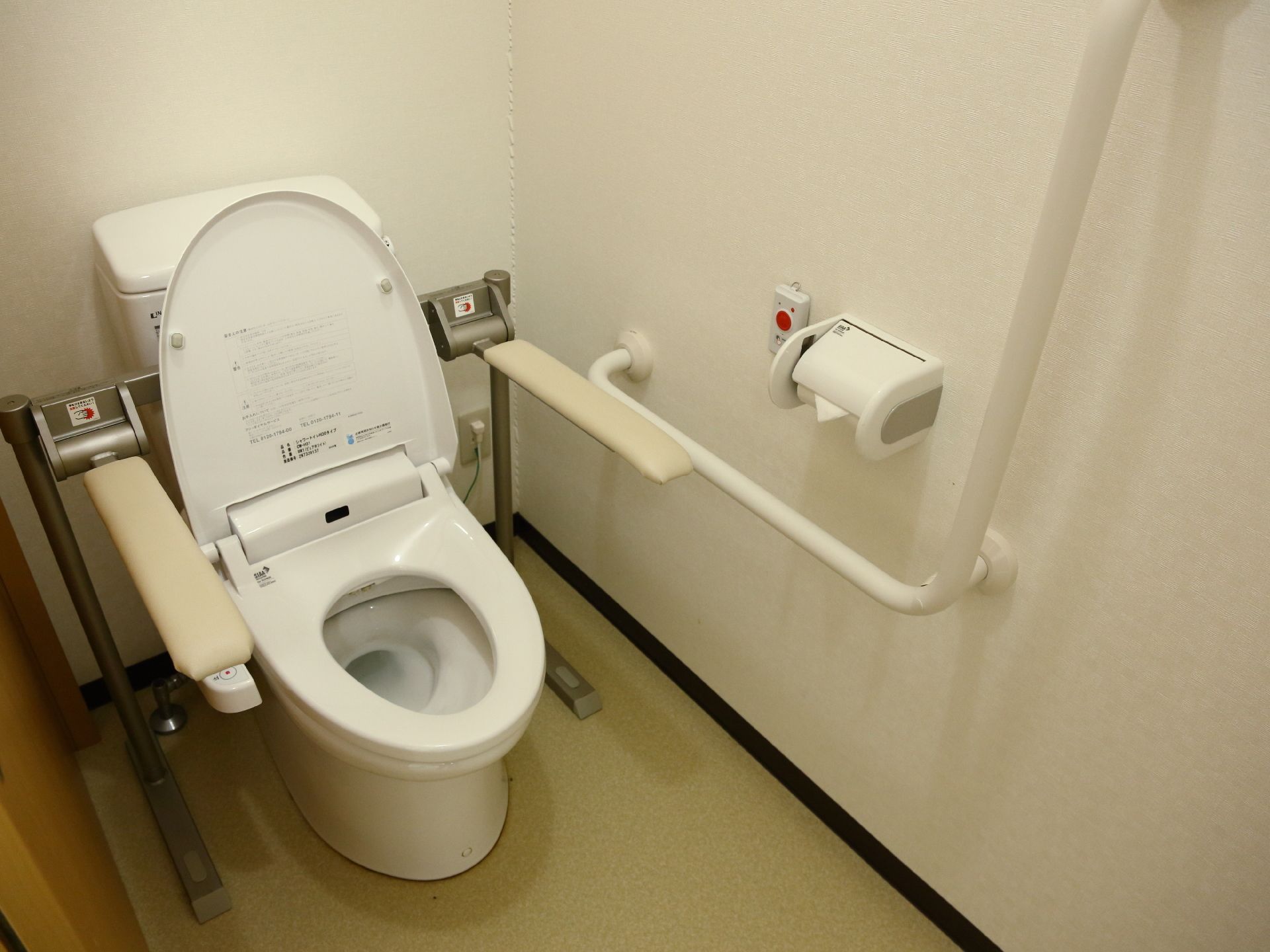 トイレの便座の両脇に、立ち座りをサポートしてくれる手すりが付いている。それとは別に壁にも、手すりがあるので安心。
