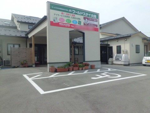 「ワールドステイ 向陽」の外観。お車の来場も問題なし。駐車場完備の、清潔感ある施設。