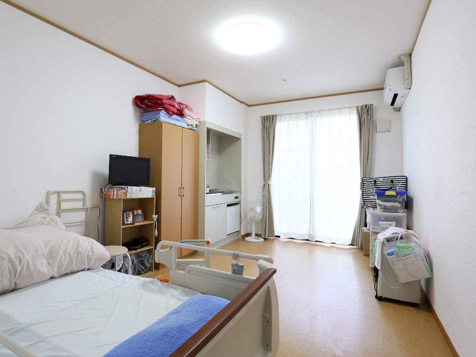ベッドやテレビ、収納家具やキッチンスペースのある個室