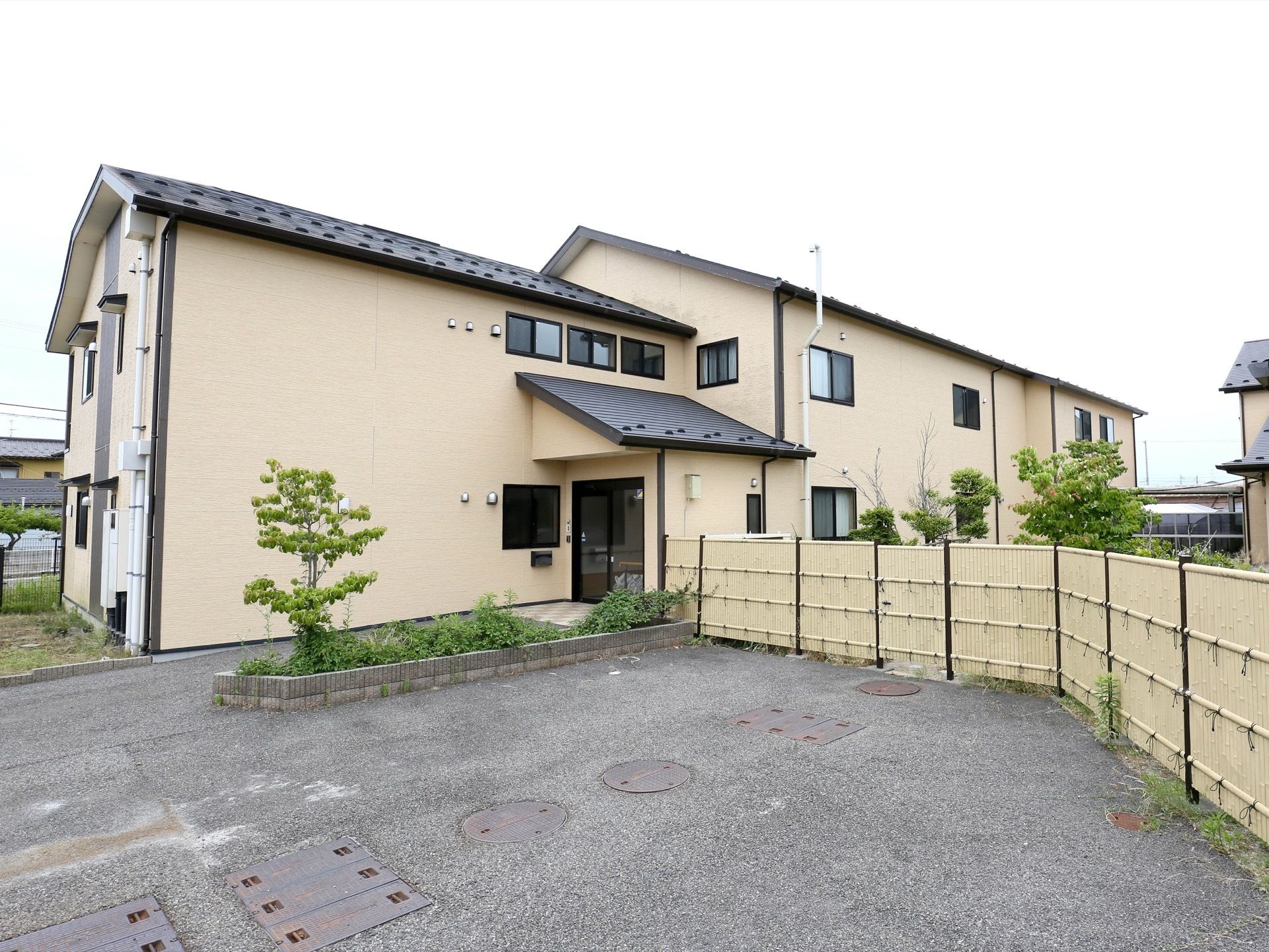 建物の外観は集合住宅のようで、エントランスのそばに駐車できるスペースが設けられている。安全のため周囲には柵が巡らされている。