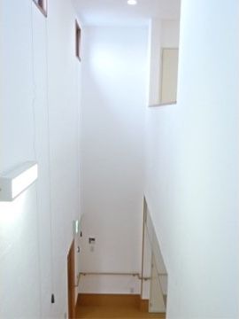 吹き抜けにある窓から明るい陽射しが差し込む、手すりが完備された廊下