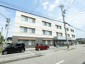 施設の前に車が四台停めることができるスペースがある。施設は三階建である。玄関の右手に自動販売機が置いてある。