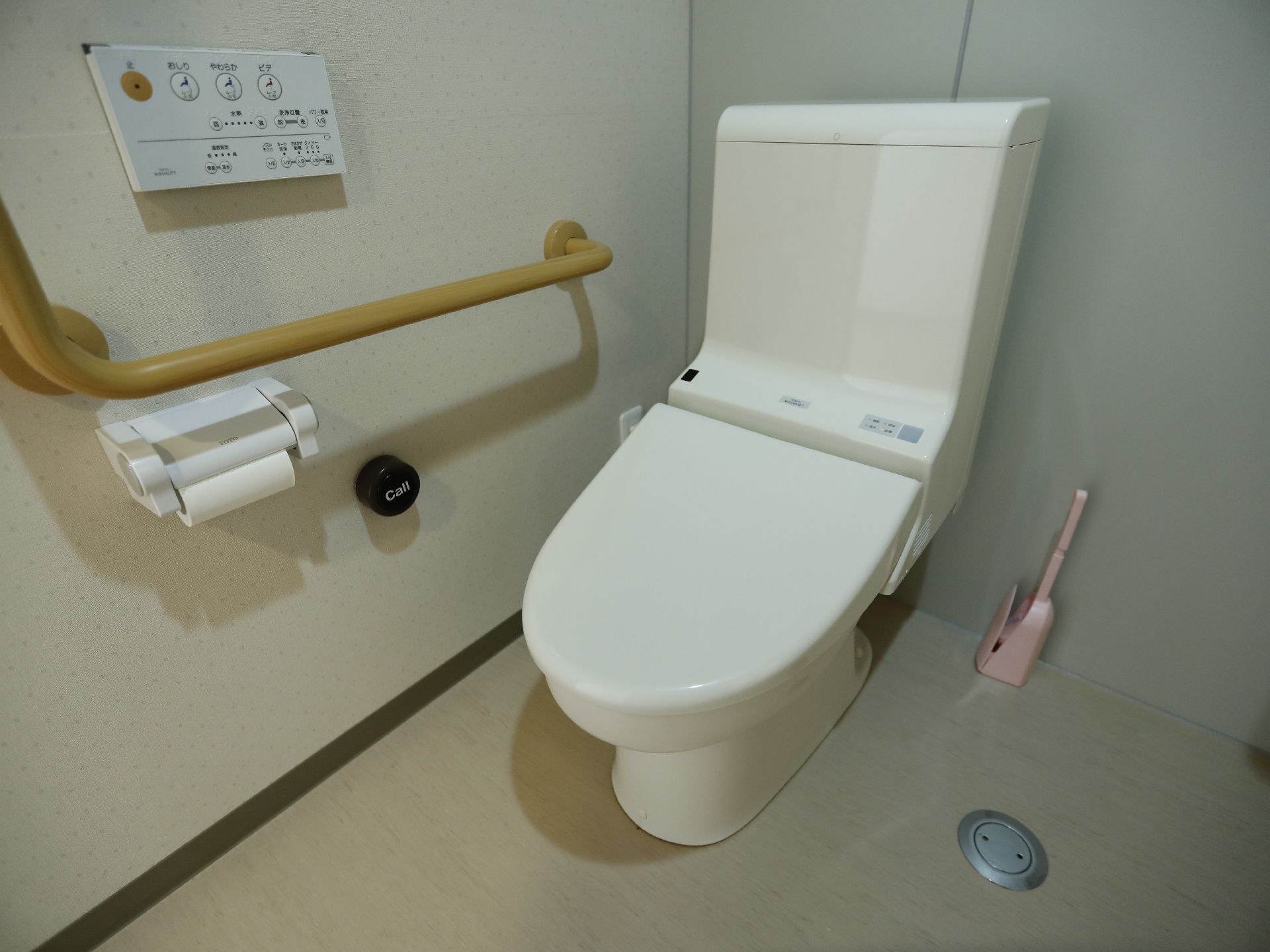 温水洗浄機のリモコンが壁に取り付けてある。トイレットペーパーホルダーのそばに、コールと書かれた呼び鈴が取り付けてある。