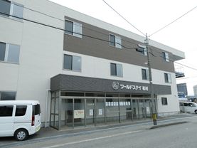 施設外観の様子が分かるようになっており、上部には施設名の入った看板が掲げられている。また、その横には車が一台停まっている。