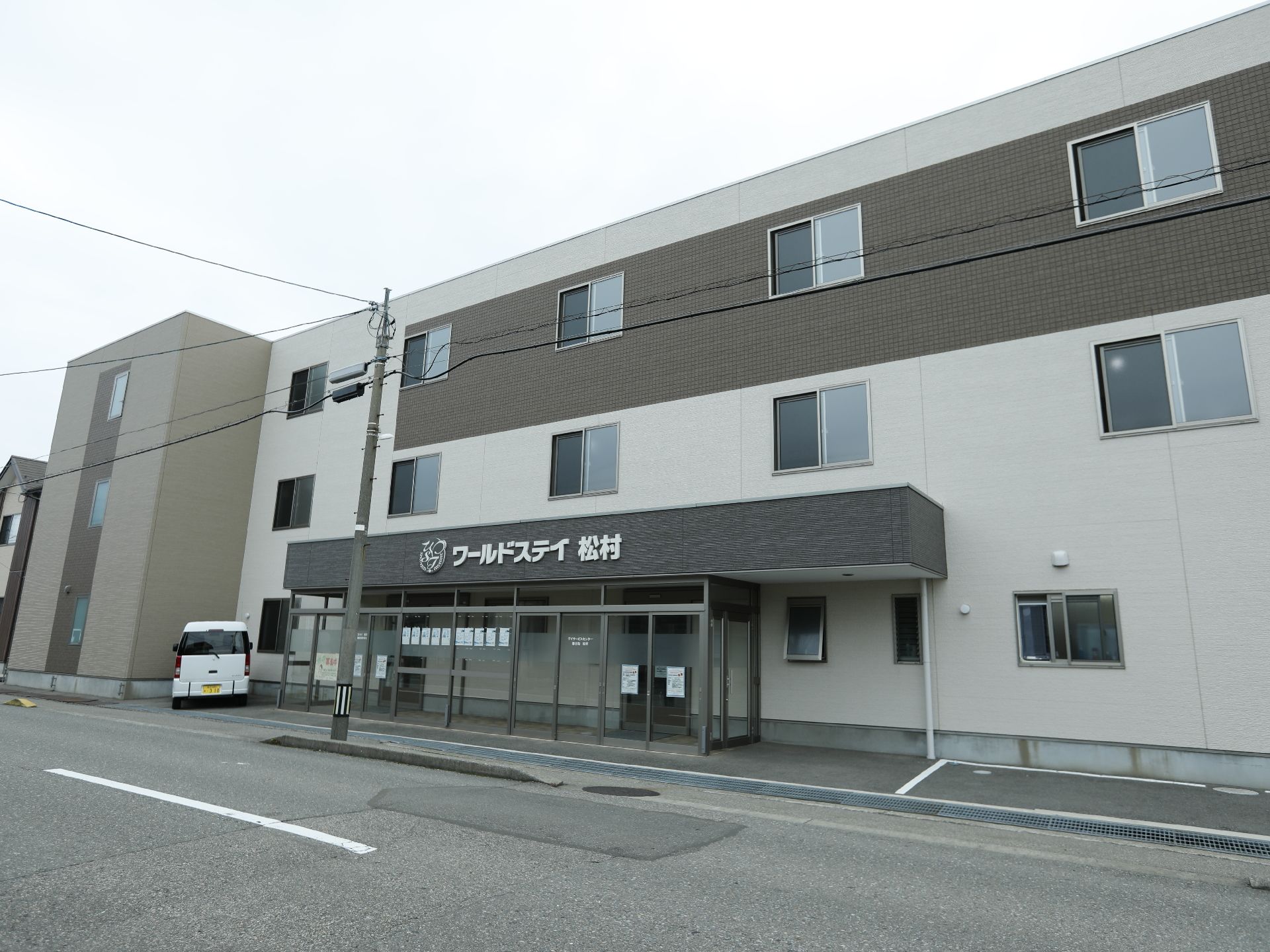 地上3階建て、白と茶のスタイリッシュな外観の建物で、道路に面して建っている。玄関の庇に大きく施設名が入っている。