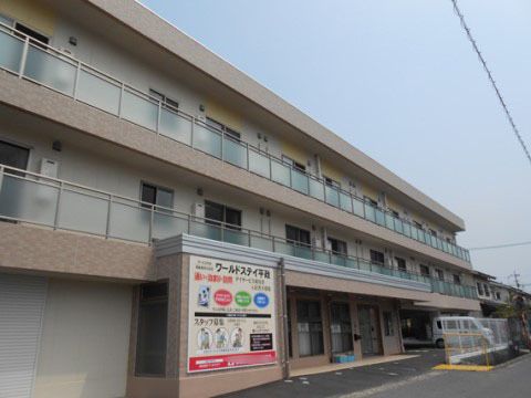 明るいブラウンのアクセントが印象的な3階建ての建物