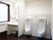 男性用の共用トイレ。洗面台付近、便器、壁に手すりが設置されており、自分でトイレに行くことを応援する設計。