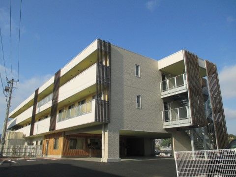 高齢者施設の外観。3階建で1階が駐車場になっている。