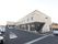 広々とした敷地に2階建てで立地して施設の外観。建物の前にはコンクリートで整備された駐車場が設けられている。