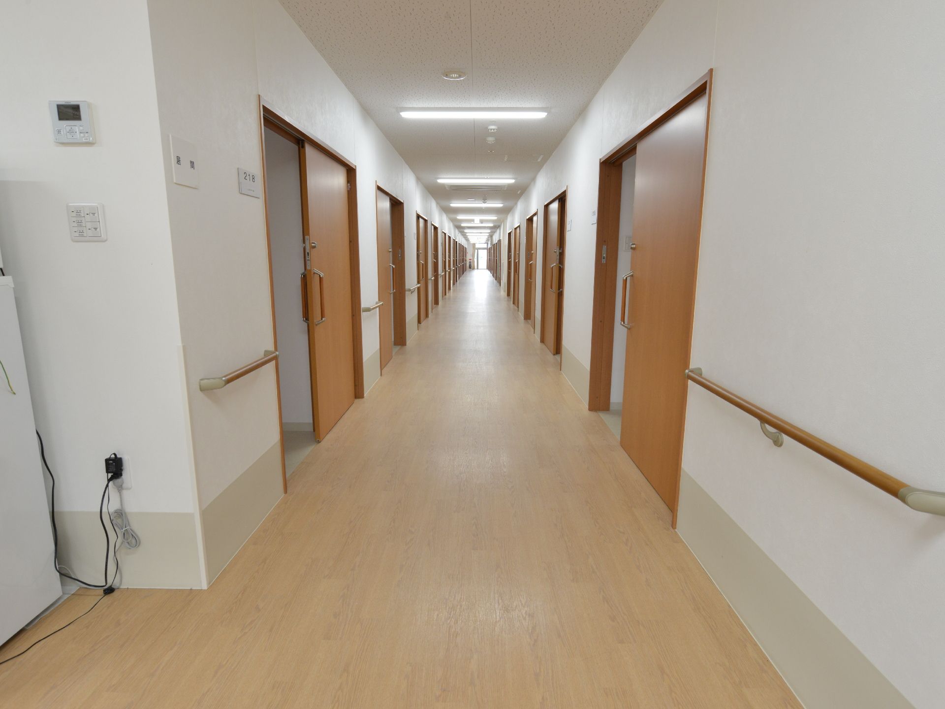 真っ直ぐに伸びた通路である。壁には手すりがついている。車椅子の人でも安全に移動できるほどの広さがある。