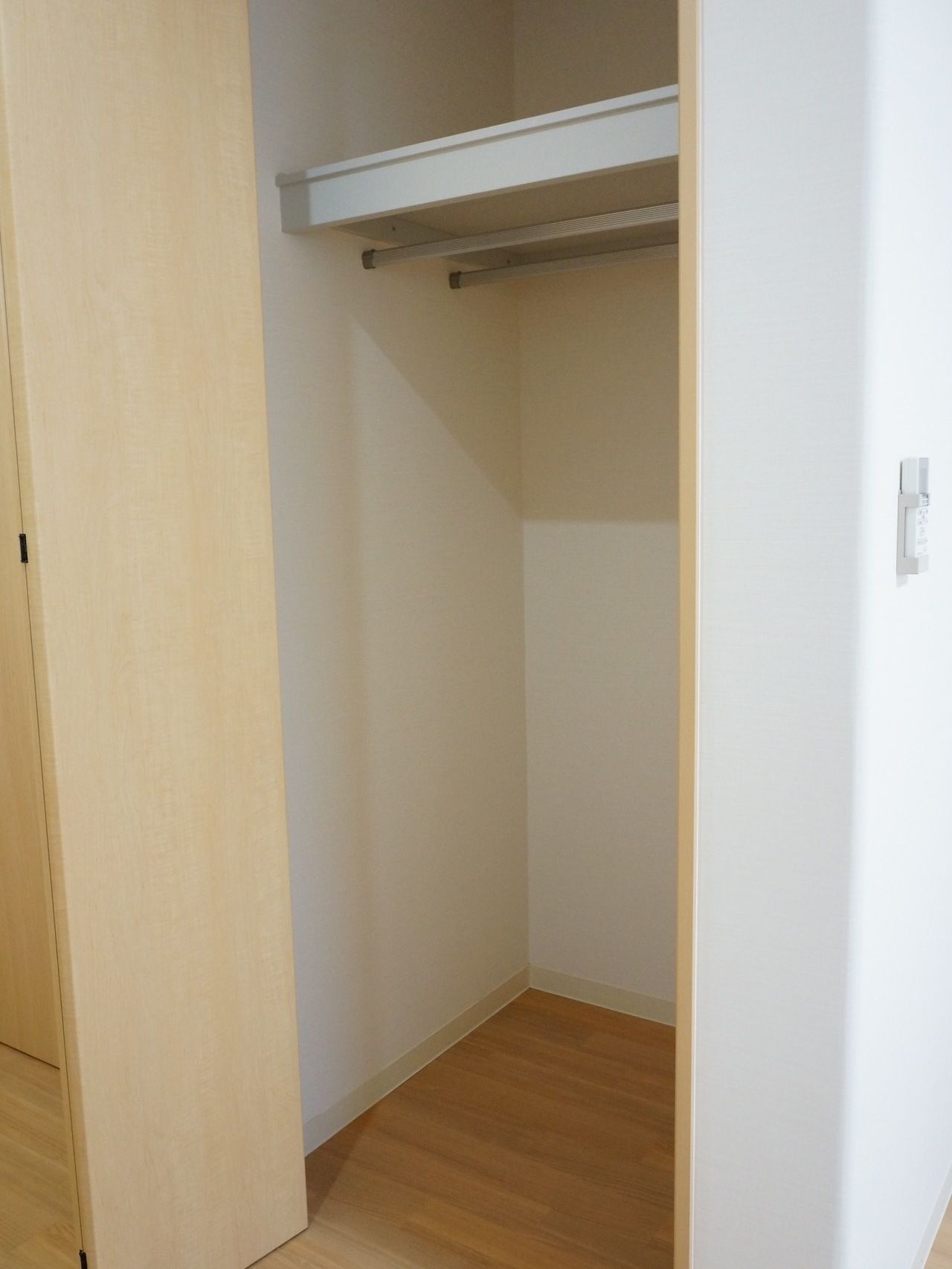 クローゼットにはハンガーレールが二本備わっておりたくさんの服を収納できる。また上部に棚板があるので、この上にも収納することができる。