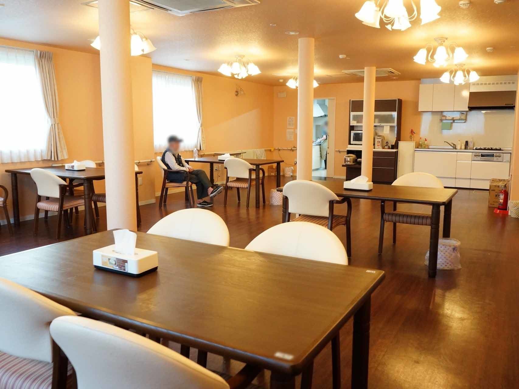 ４人掛けのテーブルが並ぶ食堂には、車椅子の方がそのまま食卓について頂けるよう、椅子が置かれていない場所がある。