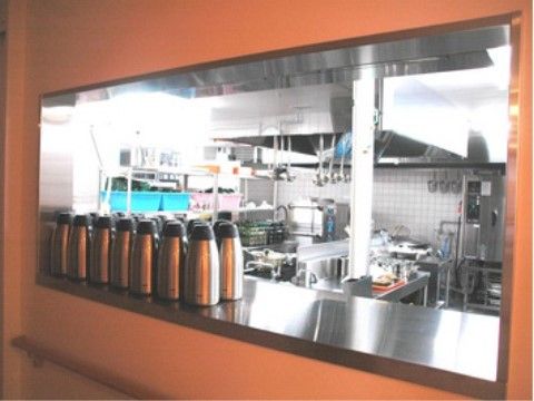 入居者様とスタッフが顔を合わせられるよう、茶色の大きな枠が設けられている。豊富な設備が整った厨房である。