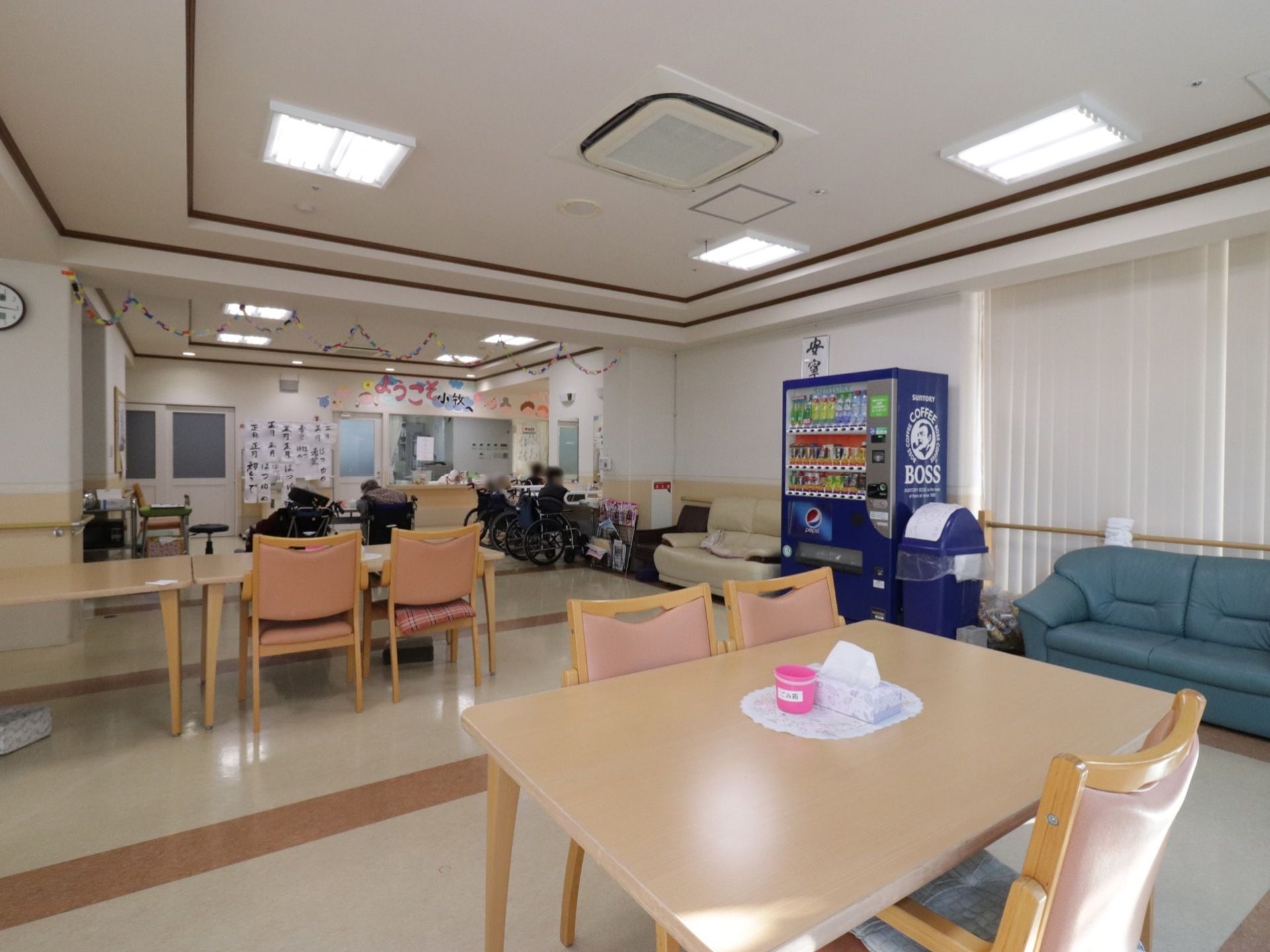 机と椅子、ソファが並べられた食堂。飲み物の自動販売機が設置されている。また、折り紙で作られた装飾が壁に施されている。