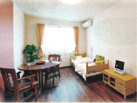 居室は広く、車椅子での移動も楽にできる。シンプルなベッドやテーブルなどが置かれており、エアコンが備え付けられている。