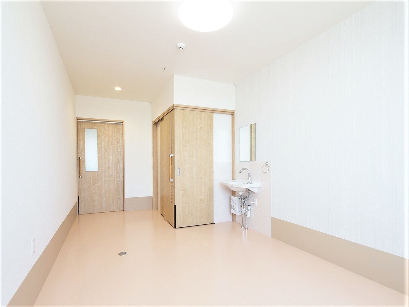洗面台とトイレが設置してある施設内の居室の様子。オールバリアフリーの床が見えている様子